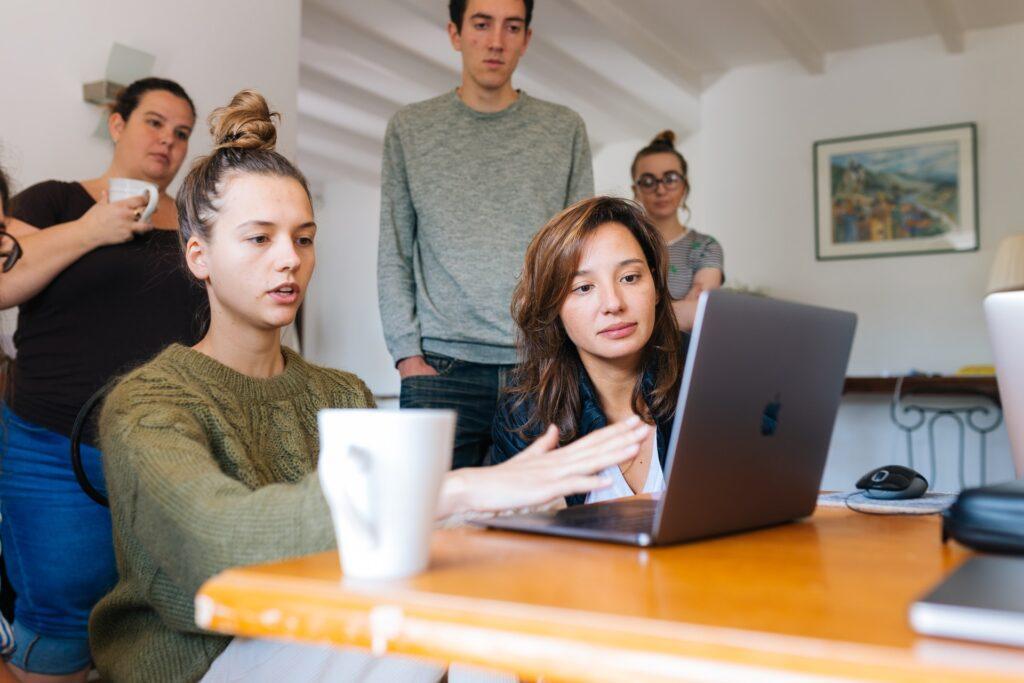 a group of people looking at a computer