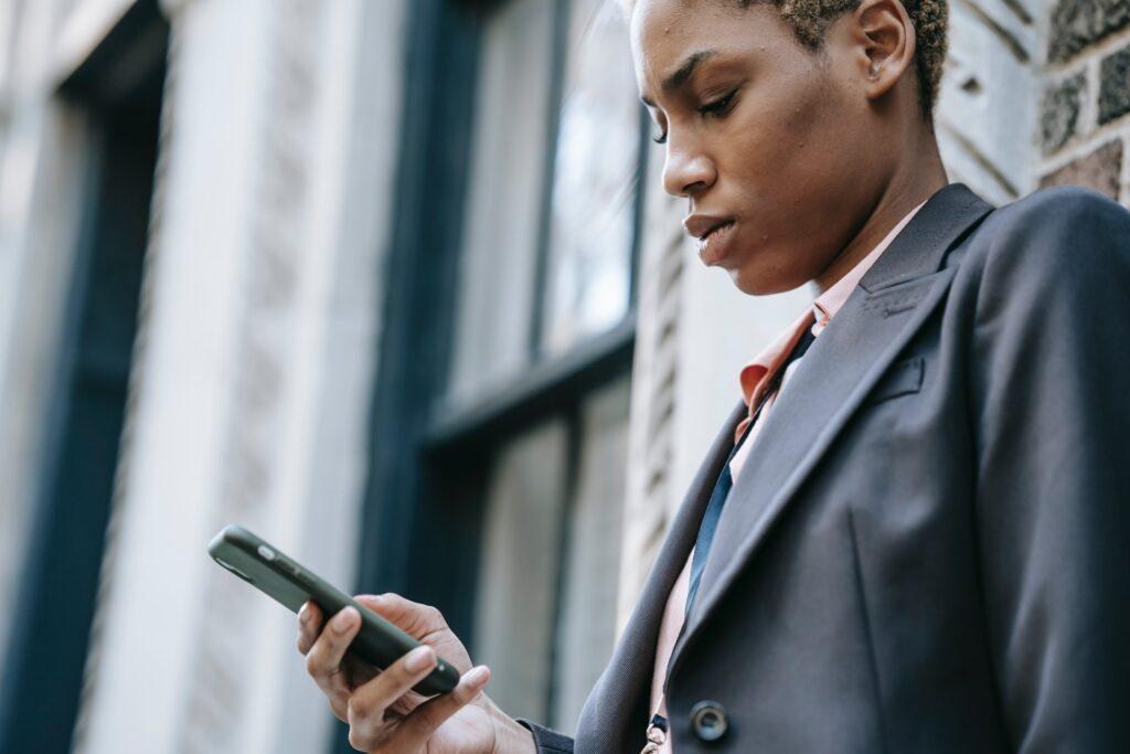 concentrated ethnic businesswoman with smartphone