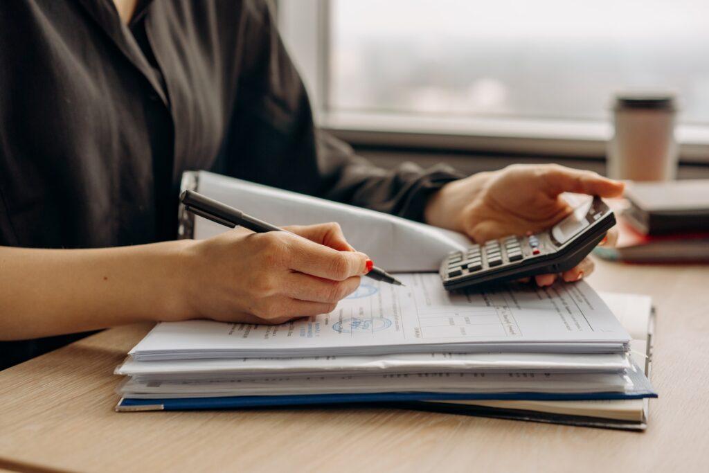 person in long sleeve shirt holding a calculator