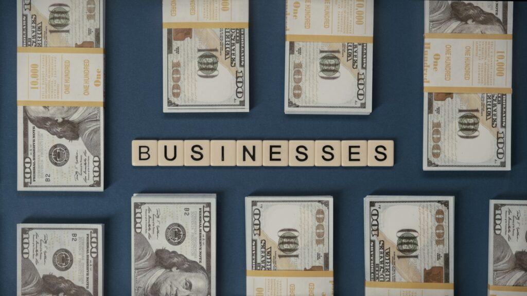 100 dollar bills beside letter tiles